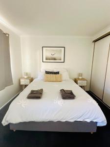 a bedroom with a large white bed with towels on it at Island Villas - Lady Elliott - Unit 2 in Bundaberg