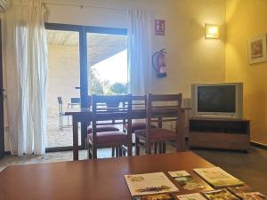 a living room with a table and a television at Camping AGUAS CLARAS in La Acena de la Borrega