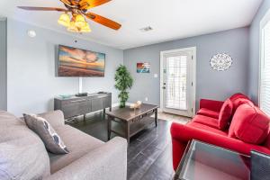 a living room with red furniture and a ceiling fan at Absolute Beach in Destin