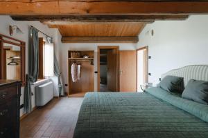 a bedroom with a green bed and a bathroom at Casa Rosa in Petriolo