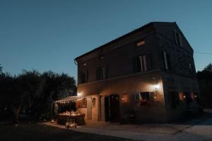 a building with a table in front of it at night at Casa Rosa in Petriolo