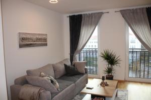 a living room with a couch and large windows at Zentrum Residenz - Wohnen auf höchstem Niveau in Leipzig