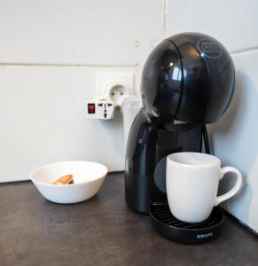 eine Kaffeemaschine auf einer Theke mit einer Tasse in der Unterkunft Studio le Petit Pantin - Cozy nest in Pantin