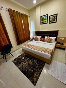 ein Schlafzimmer mit einem Bett und einem Stuhl in einem Zimmer in der Unterkunft Hotel Heaven View - 50m From Golden Temple in Amritsar