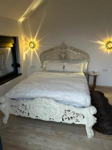 a white bed in a bedroom with two lights at Fruska Gora Villa Medici in Irig