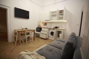 sala de estar con sofá, mesa y cocina en PATRU Apartment, en Cluj-Napoca
