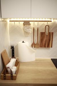 a kitchen with a shelf with wooden utensils on the wall at PATRU Apartment in Cluj-Napoca