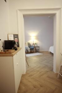 a white room with a hallway with a table and a room with a chair at PATRU Apartment in Cluj-Napoca