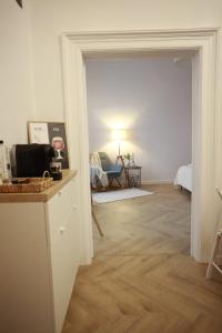 une chambre blanche avec un couloir avec une table et une chambre avec une chaise dans l'établissement PATRU Apartment, à Cluj-Napoca