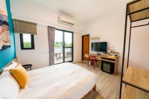 a bedroom with a bed and a desk with a computer at 水蛙春 in Hengchun South Gate