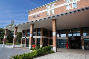 een bakstenen gebouw met een bord erop bij Hilton London Heathrow Airport Terminal 5 in Hillingdon