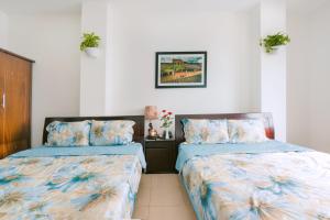 dos camas sentadas una al lado de la otra en un dormitorio en Lotus Rock Hotel Đà Nẵng, en Da Nang