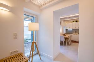a room with a floor lamp and a dining room at Valandou Guesthouses - Boutique Apartments in Aperi, Karpathos in Karpathos