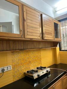 a stove top in a kitchen with wooden cabinets at Panoramic View of Lake close to Mall Road - Oasis in Nainital