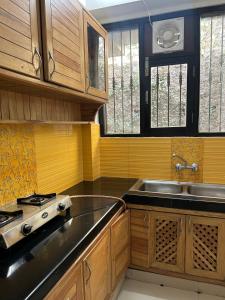 a kitchen with wooden cabinets and a sink and a stove at Panoramic View of Lake close to Mall Road - Oasis in Nainital