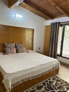 a bedroom with a large bed with a wooden headboard at Panoramic View of Lake close to Mall Road - Oasis in Nainital
