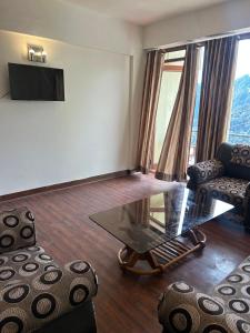 a living room with a table and two chairs and a tv at Panoramic View of Lake close to Mall Road - Oasis in Nainital