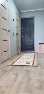 una habitación con una puerta y una alfombra delante de una puerta en 1 комнатная квартира в Павлодаре, en Pavlodar