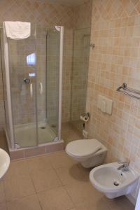 a bathroom with a shower and a toilet and a sink at Cumulus Hotel in Będzin