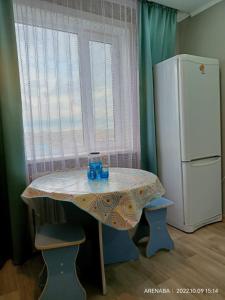 a small table and a refrigerator in a kitchen at 1 комнатная квартира в Павлодаре in Pavlodar