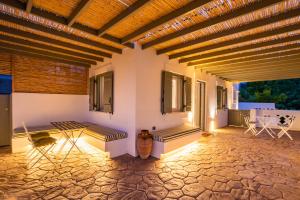 a house with a patio with benches and a table at Valandou Guesthouses - Boutique Apartments in Aperi, Karpathos in Karpathos