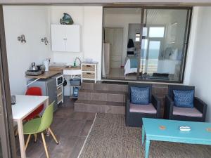eine Küche und ein Wohnzimmer mit Tisch und Stühlen in der Unterkunft Captain Sunshine Guest House in Jongensfontein