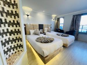 a bedroom with two beds and a large window at Luis Luxor Nile Cruise in Luxor