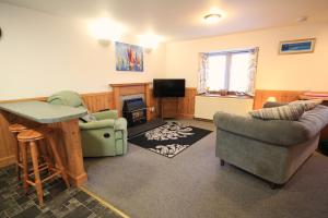 sala de estar con sofá, sillas y TV en 23 Fairfield, en Inverness