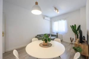una sala de estar blanca con mesa blanca y sillas en Stunning flat to enjoy Madrid, en Madrid