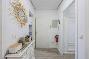 a hallway with a mirror on the wall and a door at Stunning flat to enjoy Madrid in Madrid