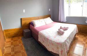 un dormitorio con una cama con un animal de peluche en Chalés do Parque Hospedagem, en Penha