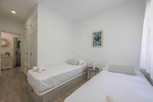 2 łóżka w sypialni z białymi ścianami i drewnianą podłogą w obiekcie Stunning flat to enjoy Madrid w Madrycie