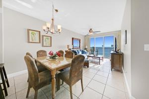 a dining room and living room with a table and chairs at Celadon 302 in Panama City Beach