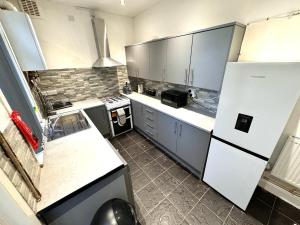 a kitchen with a white refrigerator and a stove at Bluebells of Kathleen near Birmingham Airport in Birmingham