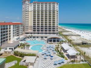 an aerial view of a resort with a pool and the beach at Hilton Pensacola Beach in Pensacola Beach