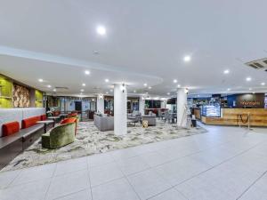 a large lobby with couches and chairs in a building at Mercure Penrith in Penrith