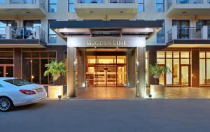 un coche blanco estacionado frente a un edificio en Apart Hotel Golden Line en Golden Sands