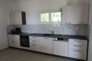 a kitchen with white cabinets and a black counter top at Studio in Villa in Kalloni direkt am Meer in Kalloni