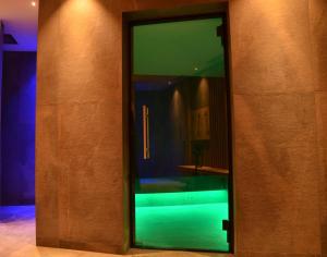 einer Glastür eines Gebäudes mit grüner Beleuchtung in der Unterkunft Kastelart - Karbon in Kastelruth