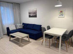a living room with a blue couch and a table at make yourself at home in Trnávka