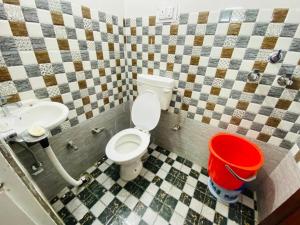 a bathroom with a toilet and a sink and a bucket at Hotel Best Stay By Hariganga Haridwar in Haridwār