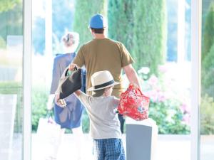 a man and a young boy walking with shopping bags at Novotel Wien Hauptbahnhof in Vienna