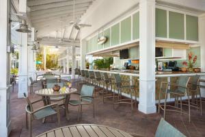 ein Restaurant mit einer Bar mit Stühlen und Tischen in der Unterkunft Hyatt Vacation Club at Coconut Cove in Estero