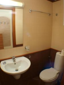 a bathroom with a sink and a toilet and a mirror at Nessebar View Apartament in Nesebar