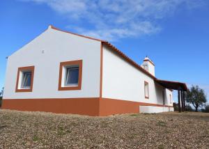 una iglesia blanca y naranja en una colina en Monte da Clareira - Comporta Carvalhal Melides, en Grândola