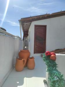 a porch with a christmas tree and vases and a door at Apartamento na Passarela in Porto Seguro