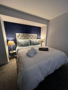 a bedroom with a large white bed with a blue headboard at Salt View in Cullen