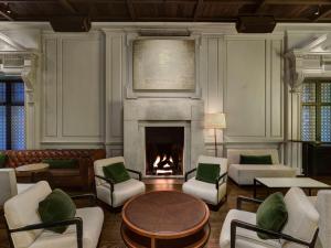 a living room with a fireplace and a table and chairs at Ambassador Chicago, part of JdV by Hyatt in Chicago