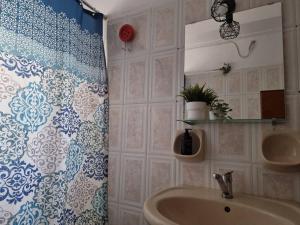 a bathroom with a shower curtain and a sink at Stavros House παραθαλάσσια μονοκατοικία in Dhílesi