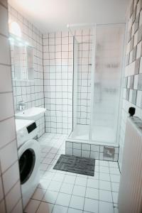 a white tiled bathroom with a shower and a toilet at Vienna Shopping Center 12 Apartment in Vienna